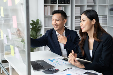 Young smart team of business people working together and presenting their idea with sticky note during the meeting time.