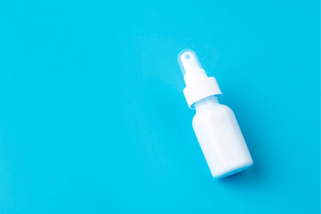 White plastic package of nasal spray on a blue background. Treatment of seasonal allergies. Top view, space for text.