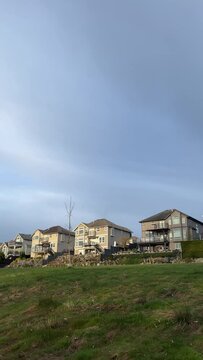 view of the private sector On a high hill, blue sky and green grass halving space for text housing for rich identical beautiful three-story houses mansions in the city of Surrey Vancouver Canada 2023
