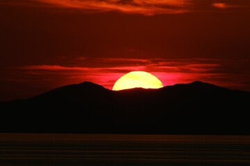 Obraz premium Sun setting behind the hills