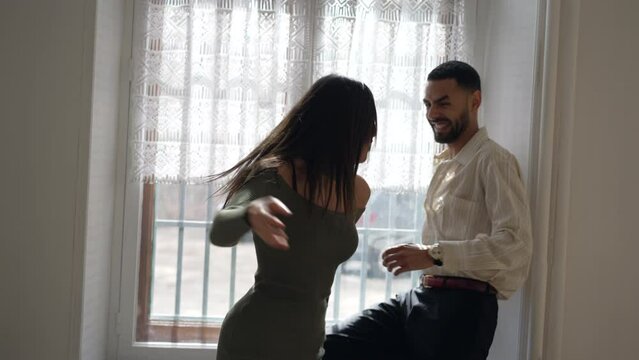 Couple teasing each other. Girlfriend pushes but embraces boyfriend in a funny manner. Candid authentic loving relationship making reconciliation after fight