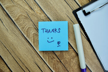 Concept of Thanks write on sticky notes isolated on Wooden Table.