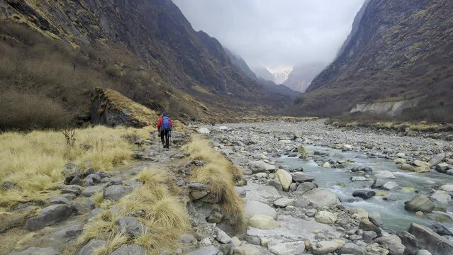 Man hiking along the Modi River in Nepal on the Annapurna circuit trek.