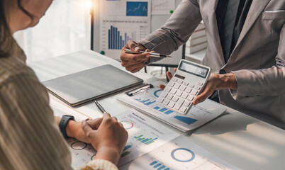 Two business people talk project strategy at office meeting room. Businessman discuss project planning with colleague at modern workplace while having conversation and advice on financial data report.