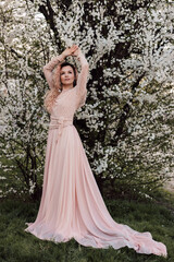 Obraz na płótnie Canvas A beautiful woman in a dress near a cherry blossom. Spring Day