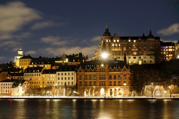 Beautiful scenery of illuminated Stockholm waterfront view towards Sodermalm district with historic Mariahissen building and Monteliusvagen, Sweden
