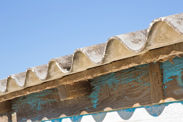 Old aged dangerous roof made of prefabricated corrugated panels with wooden structure