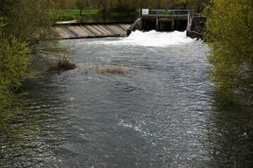 Flussströmung mit Wasserschleuse im Frühling