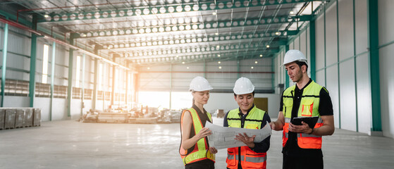 Team engineers workers planning and talking in empty warehouse to design the arrangement of product...