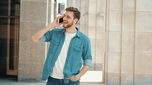handsome smiling man in casual clothes while having telephone conversation. Male talking on mobile phone. Positive model telling about his vacation