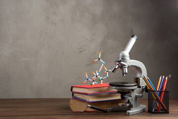 Back to school - books and microscope on the wooden desk in the auditorium, Education concept