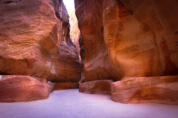 Petra w Jordanii. Wąska ścieżka między pustynnymi skałami. - obrazy, fototapety, plakaty