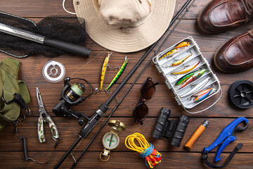 Fishing rod, tackles and other stuff for recreation activity on the wooden desk. Fishing season...
