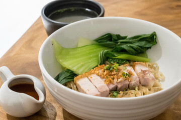 egg noodle with crispy pork, gravy, and bok choy - Asian food style.