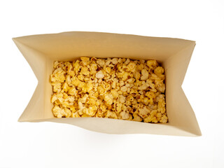 Popcorn in a cardboard box on a white background. Sweet popcorn on white. Close-up.