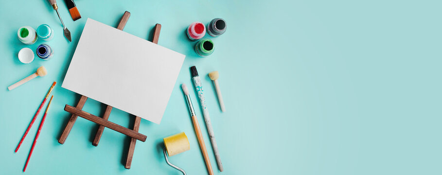 
set of accessories for painting with paints and brushes. fine art tools. creative composition in flatley style on a bright blue or turquoise background. top view. copy space.