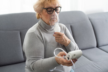 Sick senior woman has a viral infection or flu, labored breathing, asthma. An elderly female is...