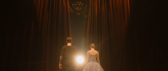 Curtains open, ballet dancers come out and perform dance on classic theater stage illuminated by...