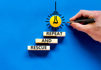Rescue and repeat symbol. Concept words Rescue and repeat on wooden block on a beautiful blue table...