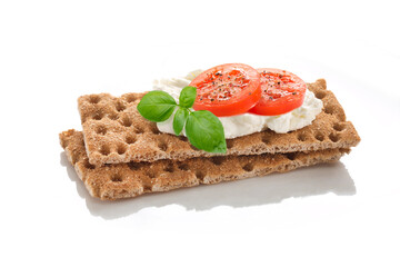 Two Slices of Crispbread with soft cottage cheese and slices of red tomatoes and cucumbers with