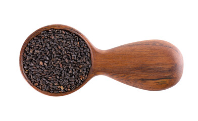 Basil seeds in wooden spoon, isolated on white background. Ocimum basilicum. Top view.