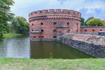ancient round watchtower and fortress walls of the fortress in the Russian city of Kaliningrad - 592389970