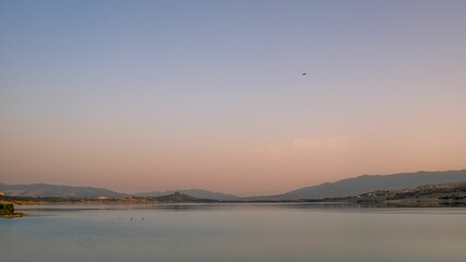 View of waterside hills under the blue and purple shaded sunset sky