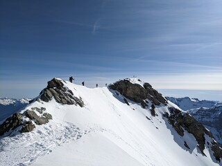 Ski tourers on the summit ridge in the direction of Gemsfairenstock. Ski mountaineering in the urner alps. Adventure skitour. High quality photo