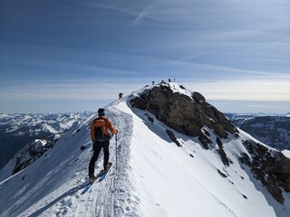 Ski tourers on the summit ridge in the direction of Gemsfairenstock. Ski mountaineering in the urner alps. Adventure skitour. High quality photo