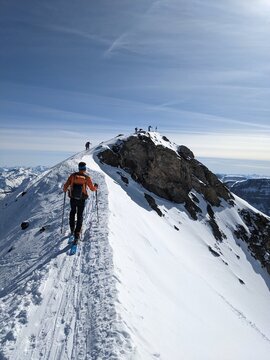 Ski tourers on the summit ridge in the direction of Gemsfairenstock. Ski mountaineering in the urner alps. Adventure skitour. High quality photo