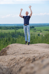 Fototapeta premium A man surrounded by mountains and forests. A man in a jump