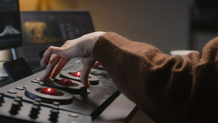 The editor uses digital color grading control panel. Colorist makes video or photo color correction on computer in studio. Tablet with footage and program interface with RGB color wheels at background