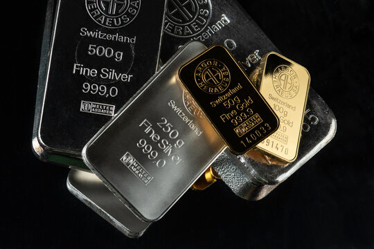Kyiv, Ukraine - January 20, 2023:  Gold and Silver bars produced by the Swiss factory Argor-Heraeus - is one of the world’s largest processors of precious metals. On a dark background.