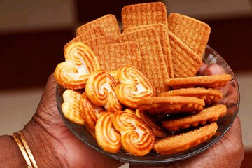 Wheat biscuits in the plate holding q woman. Indian biscuits popularly known as Chai-biscuit in India