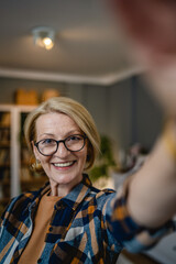 Portrait of one mature blonde caucasian woman with eyeglasses at home