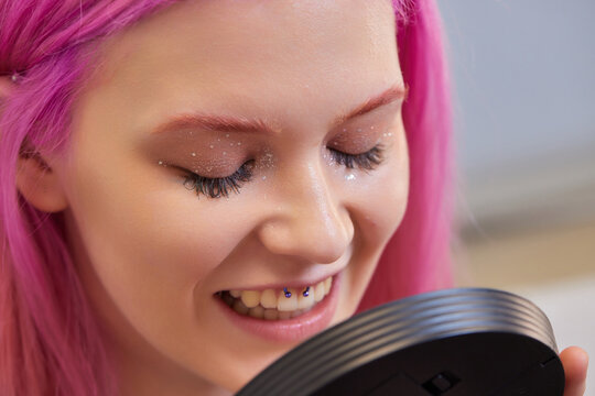 Girl lower lip piercing. Labret piercing. Macro. Blue ball.