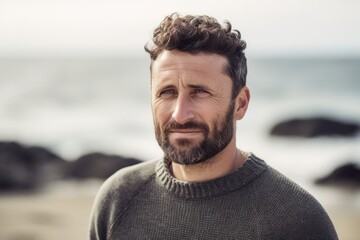Portrait of handsome man with beard looking at camera on the beach