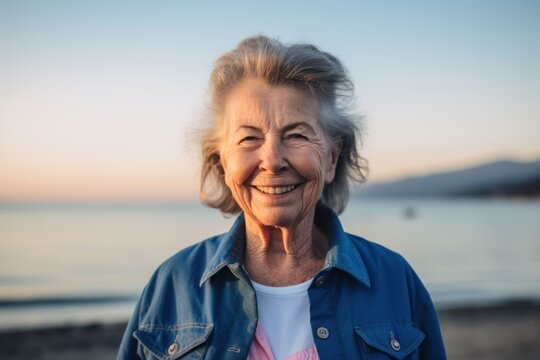 Portrait of a happy senior woman on the beach at sunset.