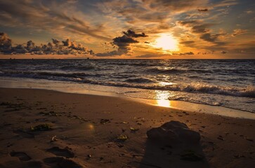 Beautiful dreamlike morning on the Baltic Sea in Gdynia, Poland. Stones on the beach in the glow of the rising sun.
