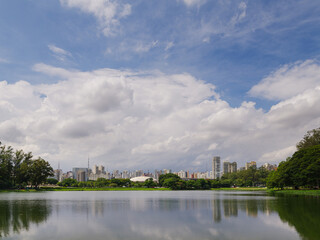 Vista da Zona Sul de São Paulo, com edifícios e reflexo em lago.
