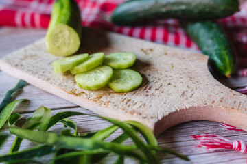Top and side view of cut cucumber on cutting board	
