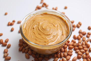 peanut butter and raw peanuts on a colored background