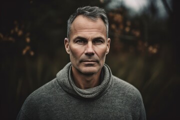Obraz premium Portrait of a handsome middle-aged man in a gray sweater.