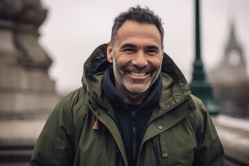 Obraz premium Portrait of handsome middle-aged man smiling and looking at camera outdoors
