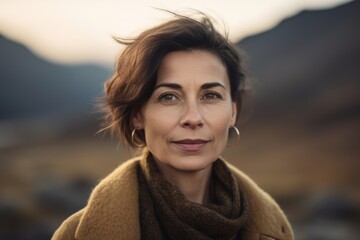 Portrait of a beautiful middle-aged woman with short hair and brown eyes in the mountains