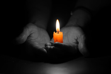 Bright Burning Candle in the Human Hands. Remembrance and Memorial Day Symbol.