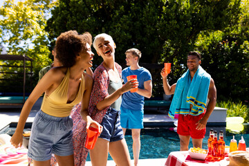 Happy diverse group of friends having pool party, dancing in garden