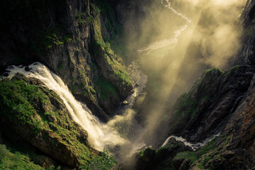 Amazing sunbeams passing through the mist created by the Voringfossen  waterfalls, Norway