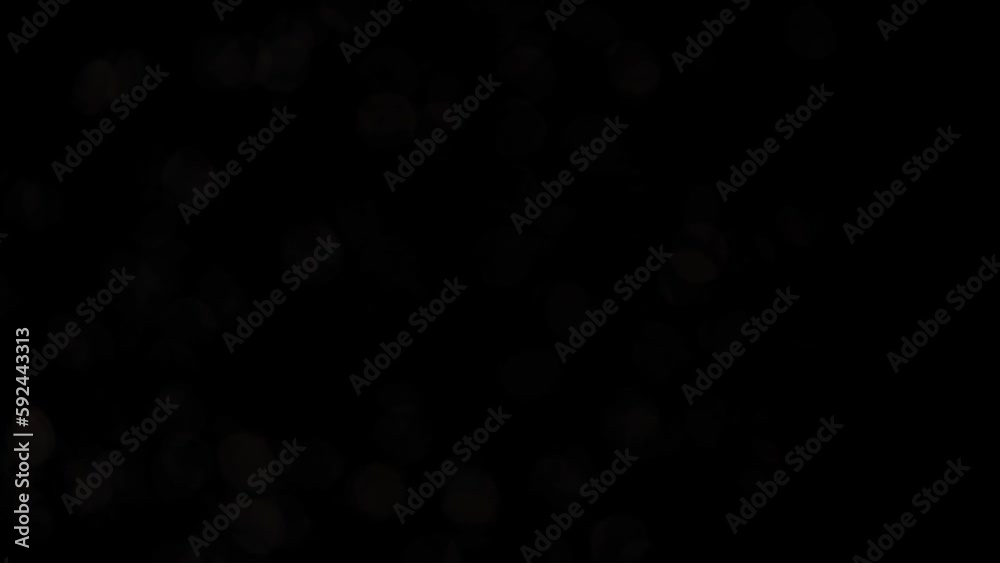 Wall mural silver bokeh transition with fading on black background. abstract moving background of metallic defo