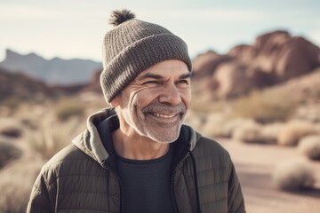 Handsome middle-aged man wearing a hat and jacket in the desert